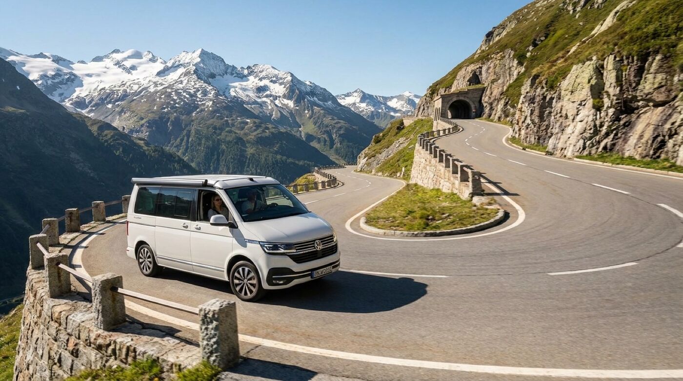 Wohnmobil auf einer Schweizer Passstraße mit Blick auf Berge und Autobahnschild